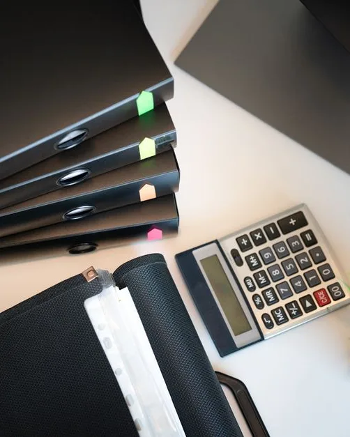 Bureau rangé avec dossiers, calculatrice et documents administratifs